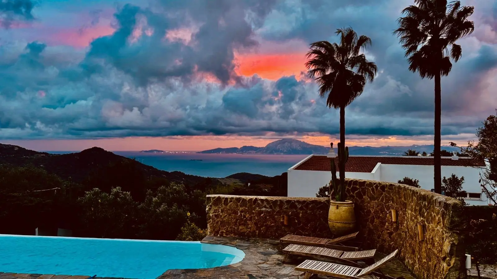 Coucher de soleil orangé sur la mer et les montagnes