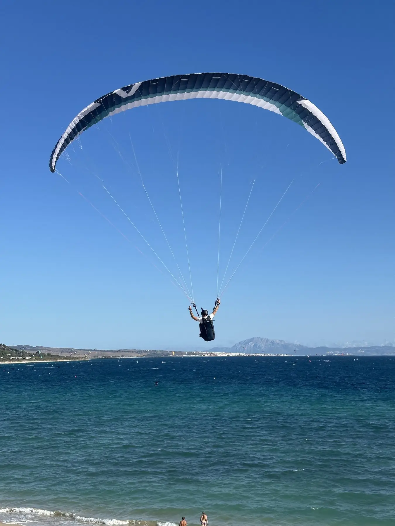 Parapente dans un ciel bleu au-dessus de la mer