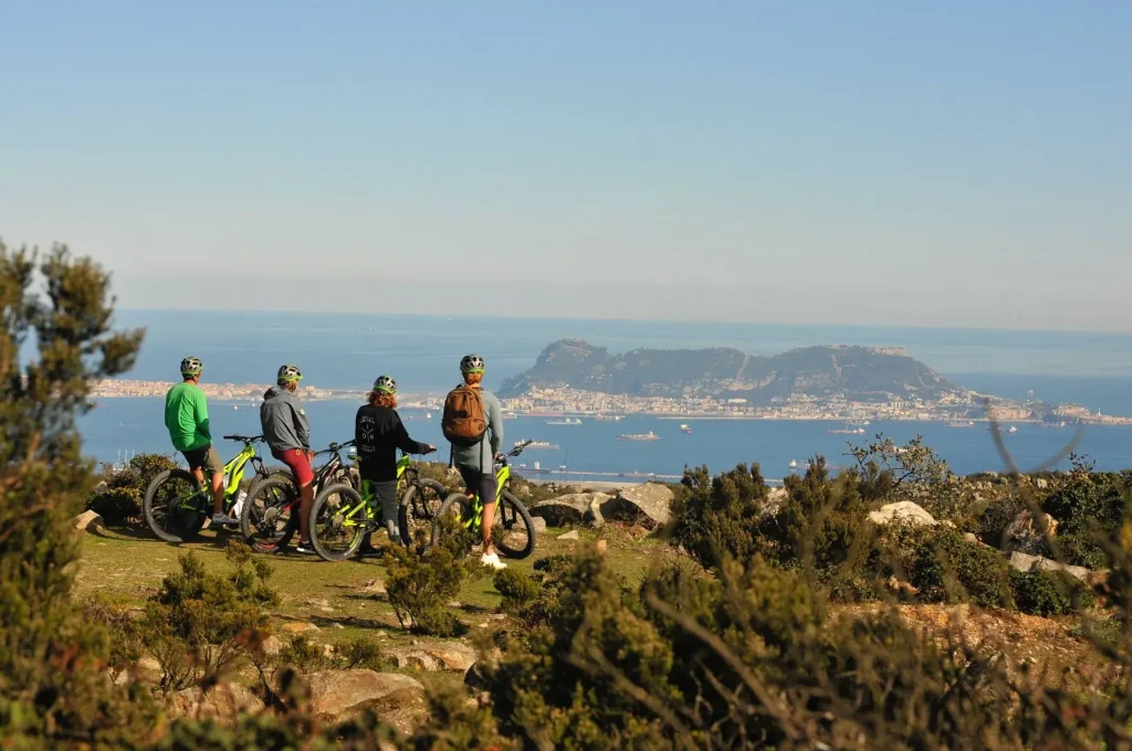 Groupe de cyclistes en VTT électrique face à un panorama sur la mer