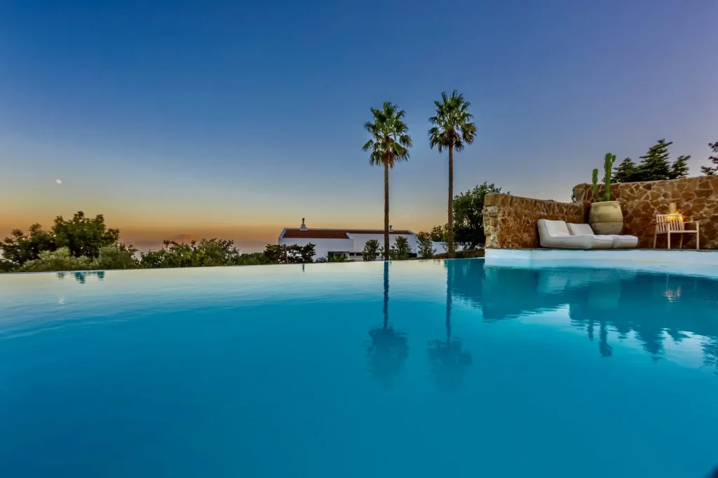 Piscine à débordement et palmiers sous un ciel bleu